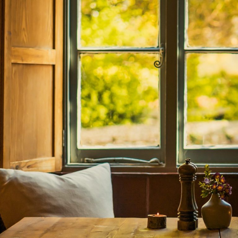 Cozy pub desking workspace at The Baker’s Arms, illuminated by natural light from a large window in The Cotswolds.