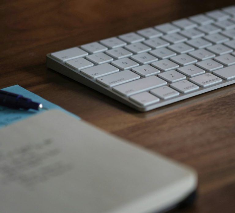 Wireless keyboard beside notepad and pen, part of the remote working kit available at The Baker’s Arms pub desking workspace.